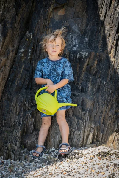 Retrato Niño Pequeño Sosteniendo Hervidor Agua Apoyado Acantilado Playa Bretaña —  Fotos de Stock