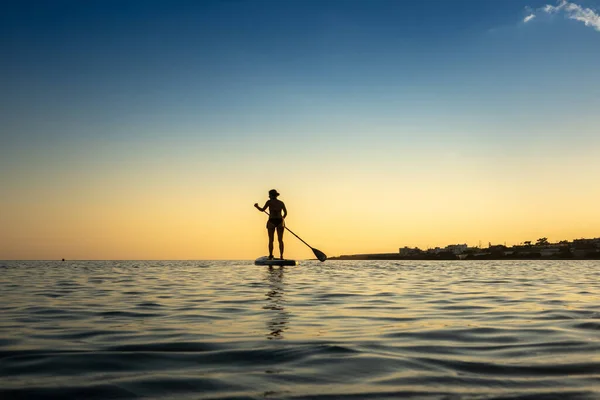 Kobieta Wiosłując Stojąco Paddleboard Oceanie Zmierzchu Przeciwko Niebu — Zdjęcie stockowe