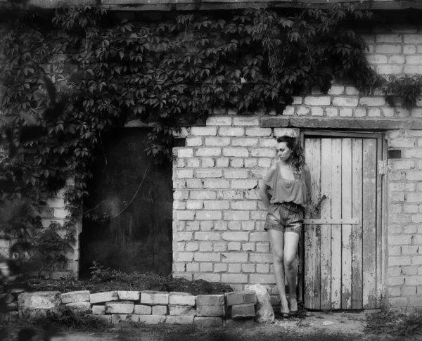 Portret van schoonheid meisje permanent in de buurt van bakstenen muur in zwart-wit — Stockfoto