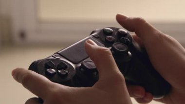 Gamepad ile oyun konsolunda video oyunu oynanıyor