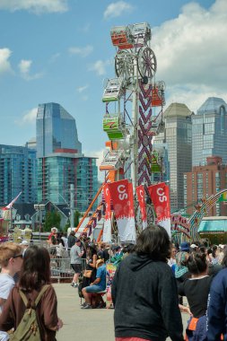 Eğlence parkı. Calgary izdihamında büyük kuyruk oluşturan insanlarla dolu dev bir yolculuk. Temmuz 08 2022 'nin başlarında, arka planda kurumsal binalarla birlikte şehir vardı.