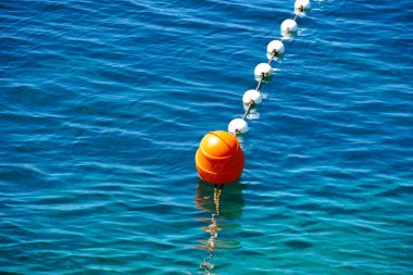 Mavi ve turkuaz deniz yüzeyinde kırmızı plastik şamandıra.