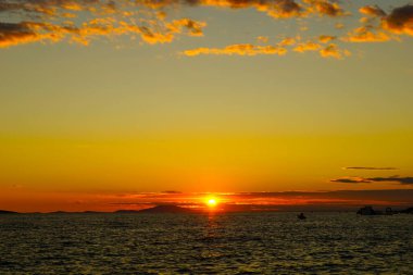 Dalgalı deniz yüzeyinin üzerindeki güneş ışığıyla güzel deniz manzarasında altın saat