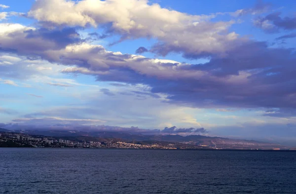 Şehrin üzerinde güzel bulutlu bir hava var. Kış rüzgarlı bir günde, deniz kıyısında.