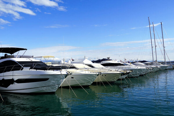 Luxury yachts anchored in the winter sea harbor with clear turquoise seawater