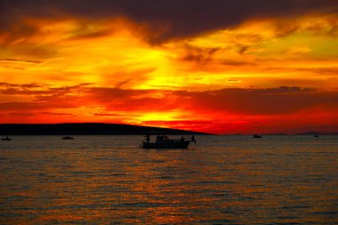 İnanılmaz ateşli ve dramatik gün batımı gökyüzü canlı turuncu ve kontrastlı koyu bulutlar