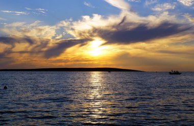 Güneş battıktan sonra deniz manzarasındaki fırtına sırasında olağanüstü dramatik ve bulutlu gökyüzü iklim değişikliğine karşı uyarıda bulunuyor.