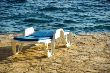 Mavi denizin kıyısındaki boş güneş panayırı yaz tatilini anımsatıyor.