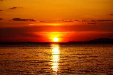 Canlı kırmızı, turuncu ve sarı renkli deniz ufku gün batımında güzel deniz manzarasında