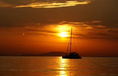 Yaz mevsiminde manzaranın yoğun deniz manzarasında siyah bir yat silueti.