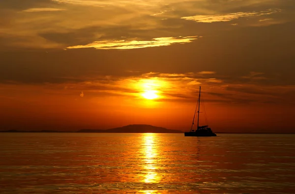Dark orange, gold and yellow color tones of stunning scenic sunset on the sea in the middle of the summer