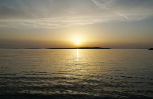 Quiet and relaxing atmosphere during the sea sunset above glassy sea surface at golden hour