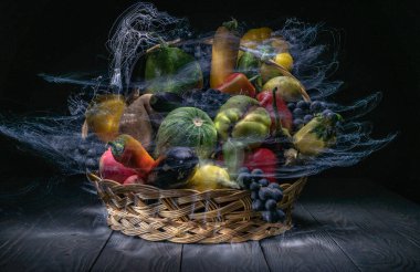 Sebze ve meyvelerle dolu bir sonbahar, ışıkla özetlenmiş bir sepetin içinde.
