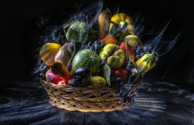 Sebze ve meyvelerle dolu bir sonbahar, ışıkla özetlenmiş bir sepetin içinde.