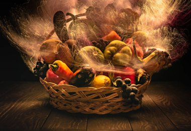 Sebze ve meyvelerle dolu bir sonbahar, ışıkla özetlenmiş bir sepetin içinde.