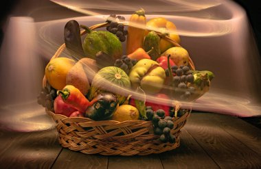 Sebze ve meyvelerle dolu bir sonbahar, ışıkla özetlenmiş bir sepetin içinde.