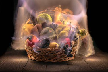 Sebze ve meyvelerle dolu bir sonbahar, ışıkla özetlenmiş bir sepetin içinde.