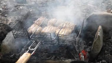Dağ ormanında ateş üstünde tavuk pişirmek.