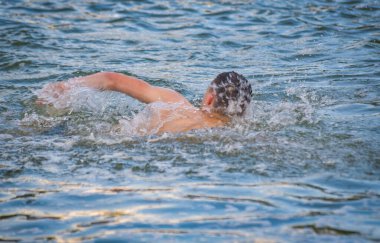 Adam bir dağ nehrinde sürünüyor.