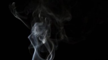 Beautiful movement of smoke in a beam of light on a dark background
