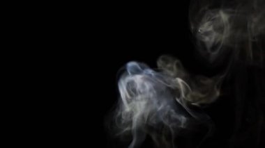 Beautiful movement of smoke in a beam of light on a dark background