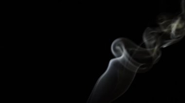 Beautiful movement of smoke in a beam of light on a dark background