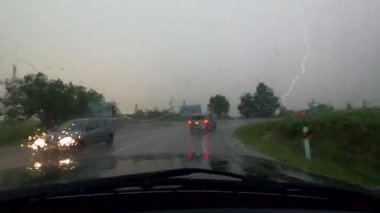 Kasırganın ortasında şiddetli bir yağmurda bir SUV otobanda sürüyor.