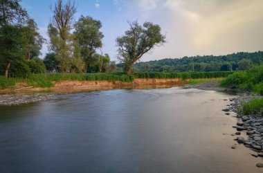 Bir yaz akşamında bir dağ nehrinin manzarası