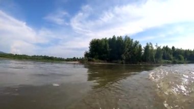 Bir yaz akşamı akan bir dağ nehrinin manzarası.