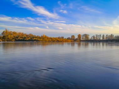 Gün batımında bir dağ nehrinin sonbahar manzarası