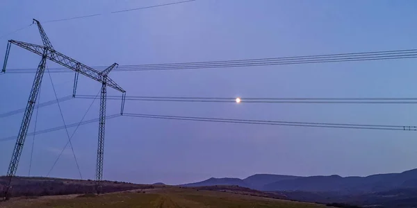 高原上有巨大电线杆的夜景 — 图库照片