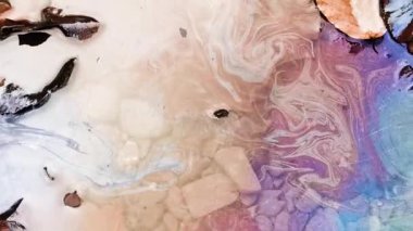 Dağ nehrinin yüzeyinde desenli gökkuşağı benzin lekesi