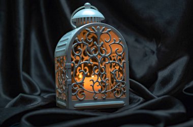 Karanlık arka planda yanan mumu olan şenlikli fener.