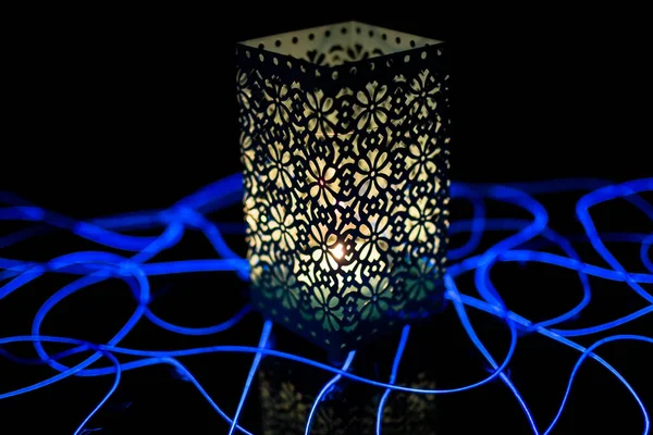 Karanlık arka planda yanan mumu olan şenlikli fener.