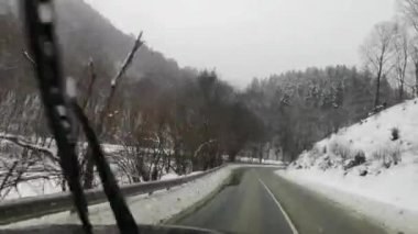 Bir SUV kışın Karpatlar boyunca seyahat eder.
