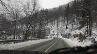 Bir SUV kışın Karpatlar boyunca seyahat eder.