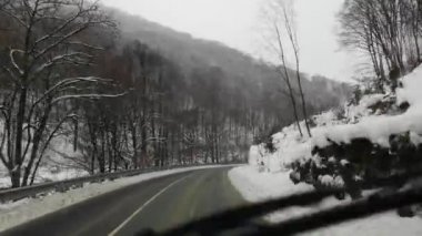 Bir SUV kışın Karpatlar boyunca seyahat eder.