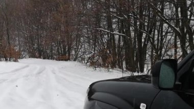 Bir SUV kışın Karpatlar boyunca seyahat eder.