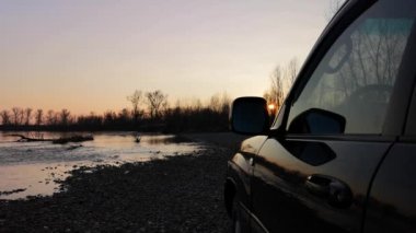 Bir dağ nehrinde akşam üstü SUV ile