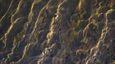 Güneşli bir dağ nehrinin desenli dalgaları