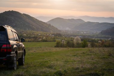 Bir SUV ilkbaharda Karpatlar 'ın kırsal bölgelerinde dolaşır.