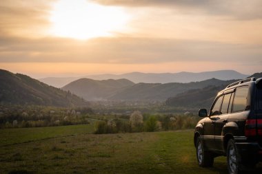 Bir SUV ilkbaharda Karpatlar 'ın kırsal bölgelerinde dolaşır.