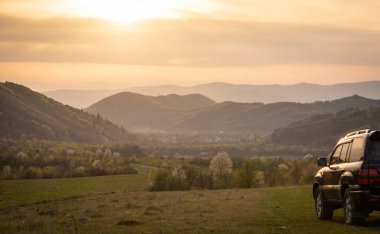 Bir SUV ilkbaharda Karpatlar 'ın kırsal bölgelerinde dolaşır.