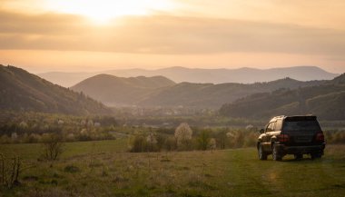 Bir SUV ilkbaharda Karpatlar 'ın kırsal bölgelerinde dolaşır.