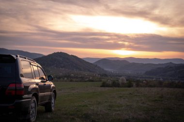 Bir SUV ilkbaharda Karpatlar 'ın kırsal bölgelerinde dolaşır.