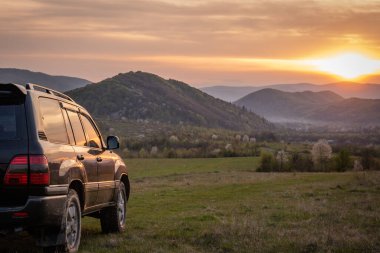 Bir SUV ilkbaharda Karpatlar 'ın kırsal bölgelerinde dolaşır.