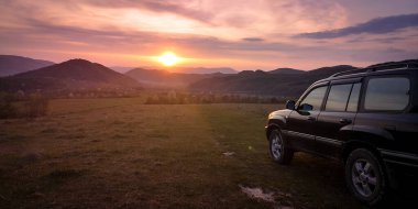 Bir SUV ilkbaharda Karpatlar 'ın kırsal bölgelerinde dolaşır.