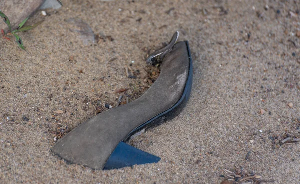 Women's shoe in the sand on the shore