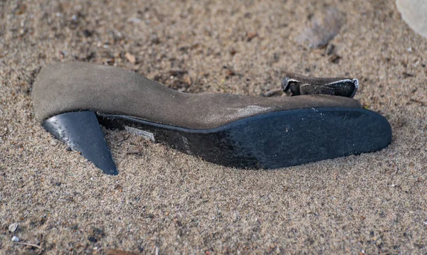 Women's shoe in the sand on the shore