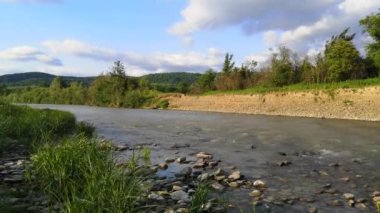 Gün batımında bir dağ nehrinin peyzaj süresi doluyor.